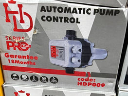 Boxes of automatic pump controls with visible branding on a surface.